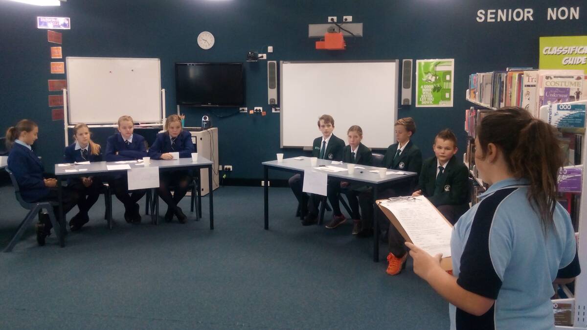 Debate: Bulahdelah Central School team is on the left and Bungwahl's team is on the right, with timekeeper Raylee Kierens pictured in front.