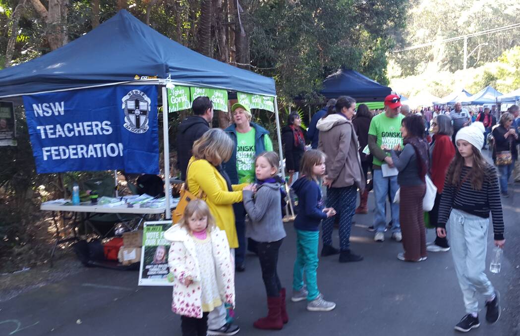 Talking to visitors at the markets are Mel Johnson, Marissa Holland and Chris Williams in their green Gonski shirts.
