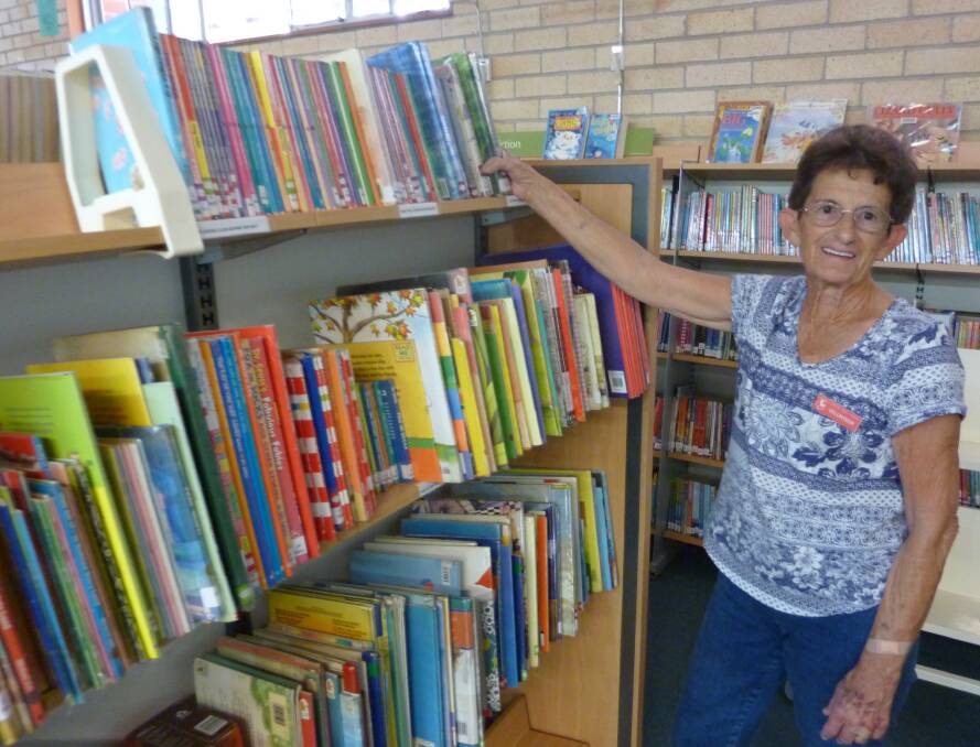 Community helpers are very valuable. Helen Fletcher shelving books and is  affectionately known as Forster Public School's Guardian Ange.