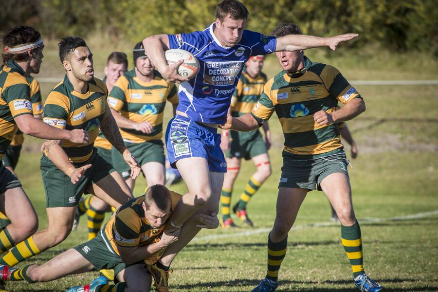 Last season’s major semifinal with Forster Tuncurry Dolphins inside-centre Mark Hagarty ankle tackling the Wallamba Bulls’ fullback, Chris Tout, with Liam Brady (headband, left), five-eighth Matt Nuku and flanker Tom Homer (right) closing in to support Hagarty. Photo Zac Lyon.