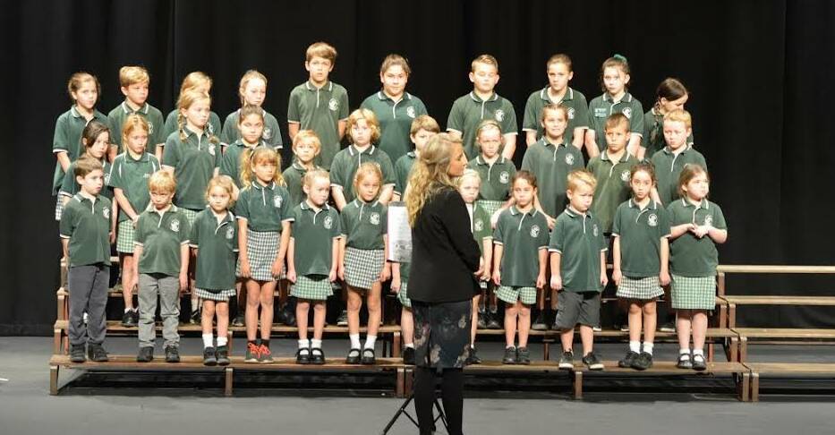 Well done: Bungwahl Public School teacher Amy Crozier leads the choir in the Taree and District Eisteddfod. The whole school, from kindergarten to year 6, performed.