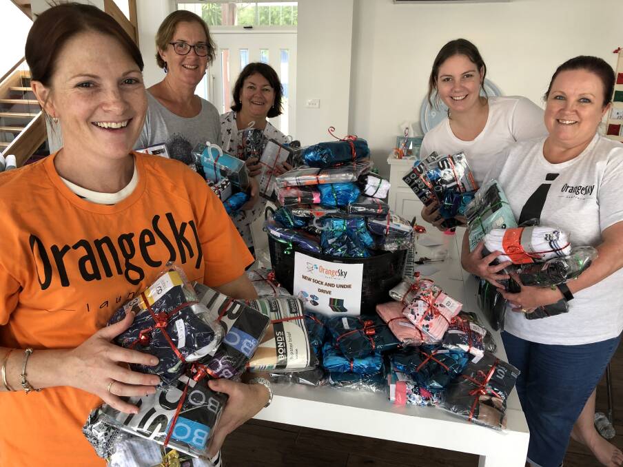 Orange Sky Laundry service manager Alison Neale, with volunteers who gathered to wrap gifted socks and undies from the Taree and Port Macquarie donation appeal. (From left) Shirley Thompson, Jenny Dykstra, Carly Bullard and Tracy Ayrton. Photo: Ainslee Dennis.