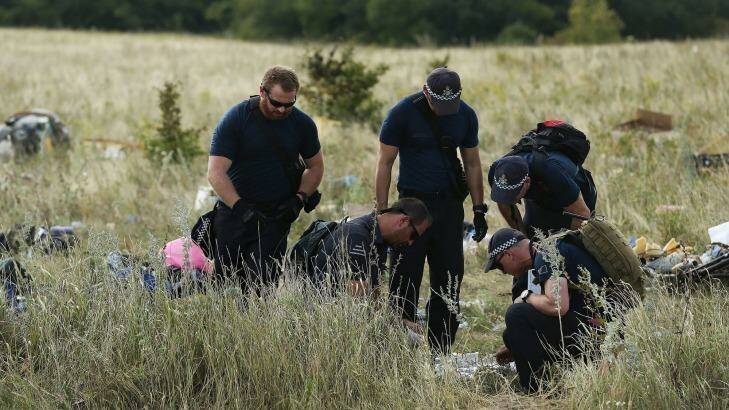 Australian Federal Police officers and their Dutch counterparts collect human remains from the MH17 crash site.  Photo: Kate Geraghty