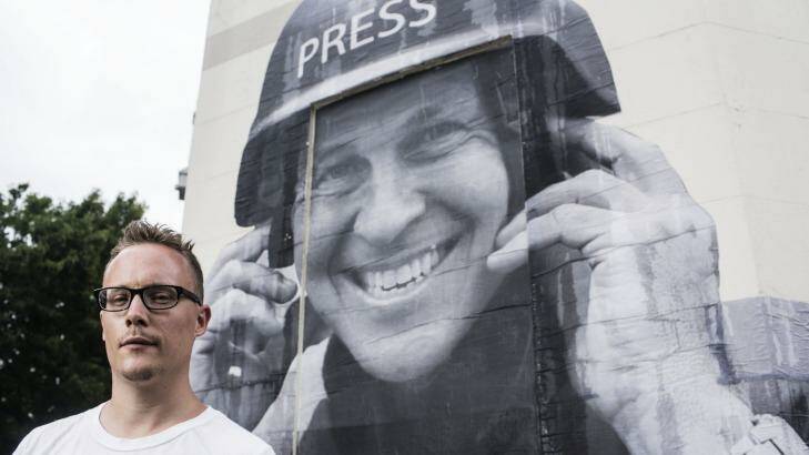 Street artist Hego with a paste up he did of jailed Journalist Peter Greste. Photo: Dominic Lorrimer