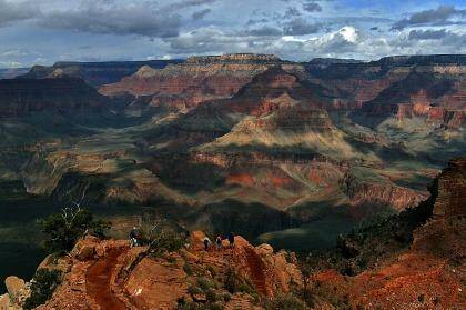 With the North Rim in the background, tourists hike along the South Rim of the Grand Canyon. 