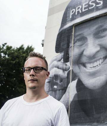 Street artist Hego with a paste up he did of jailed Journalist Peter Greste. Photo: Dominic Lorrimer