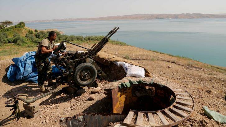 A Kurdish peshmerga fighter prepares his weapon at his combat position near the Mosul Dam. Photo: Khalid Mohammed/AP