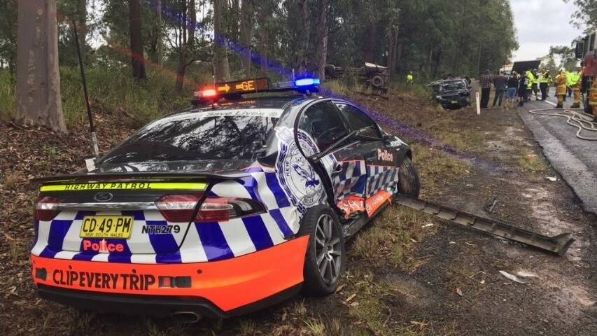Police are asking drivers to slow down in wet weather after a vehicle travelling along the Pacific Highway lost control and smashed into a parked police car.
