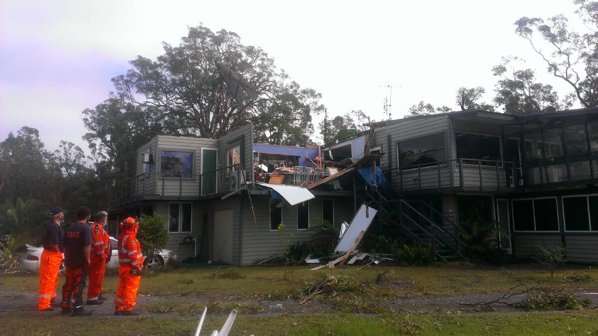 RIPPED OPEN: SES crews assess the damage to a house in Pindimar as a 
result of last week’s wild weather.   