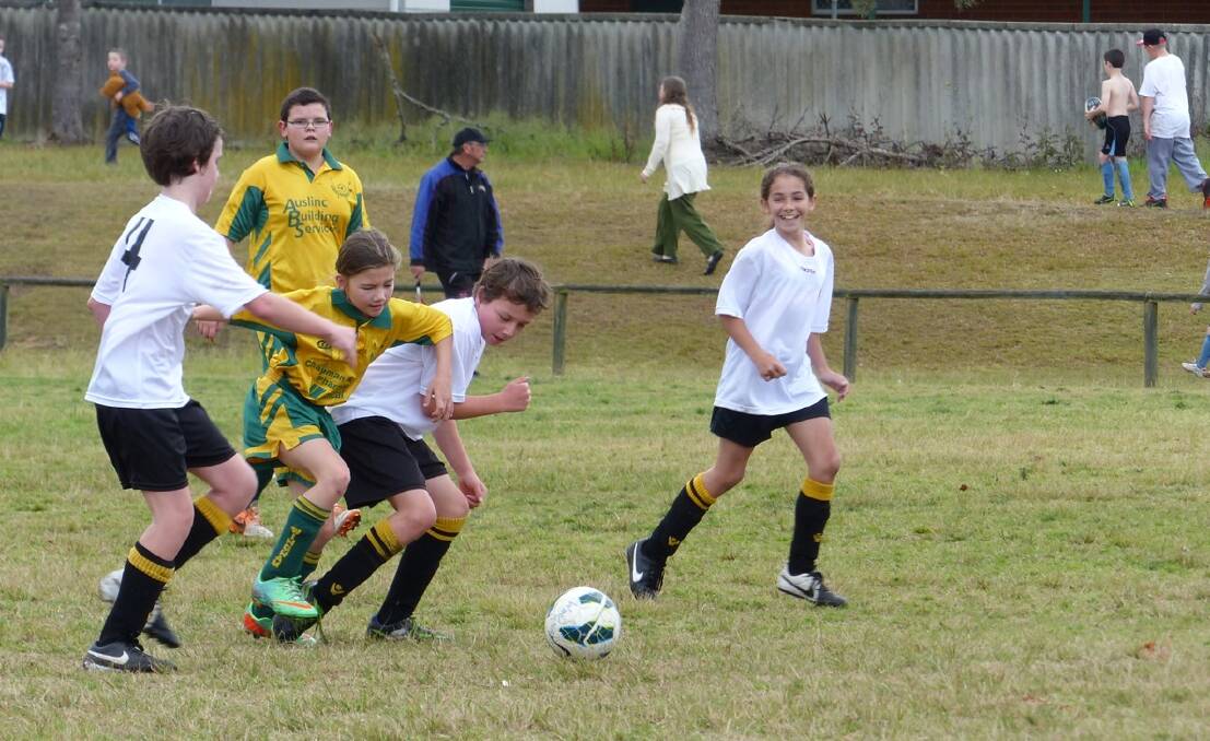 Tigers Black under 12's Josh Chalmers and Chloe Maidment watch as Joel Elliott tussles with a Wingham opponent. 