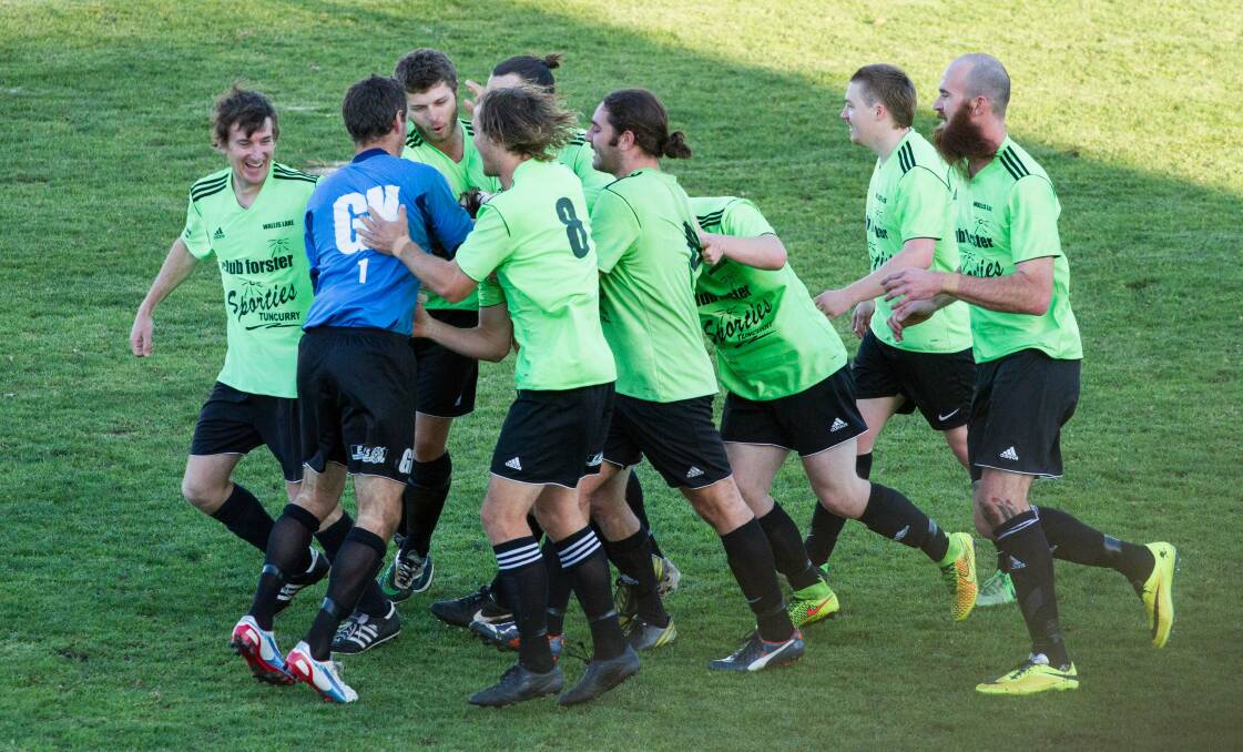 CELEBRATIONS: Wallis Lake players celebrate after Mitch Yarnold’s brilliant free kick which put the side up 1-nil. Wallis Lake will now play in the grand final after defeating Macleay Valley Rangers 3-2.  Photo by Dan Kirkman - Something Visual.  
 