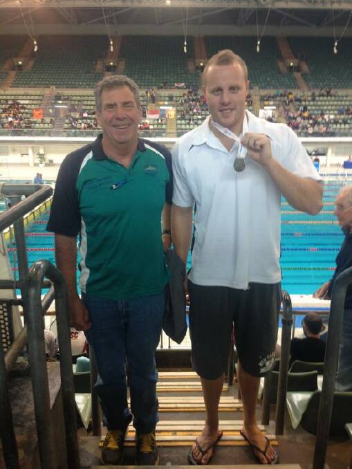 SILVER FINISH: Forster Swimming Club member Reece Turner has returned home with a silver medal after competing at the NSW State Open Swimming Carnival in Sydney recently. He is pictured with swim coach Peter Sanders.  