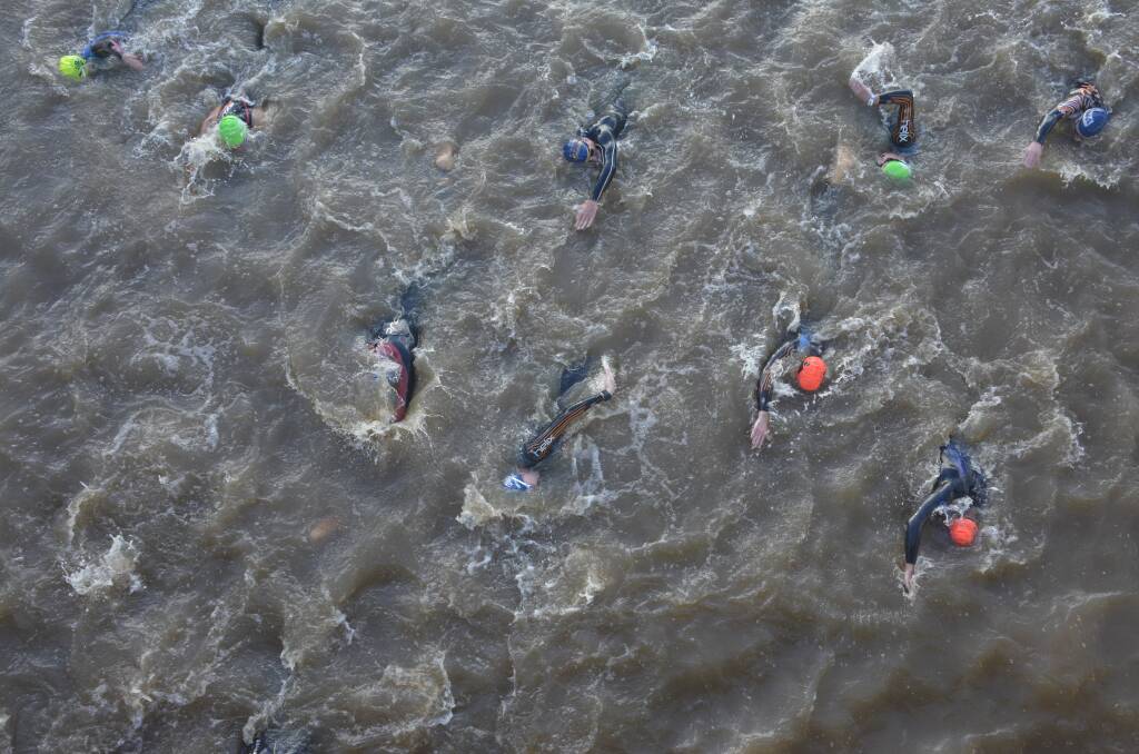 JUST KEEP SWIMMING: Competitors during the swim. The Hastings River was dirty and swollen after three days of torrential rain. Photo by Peter Gleeson.  
