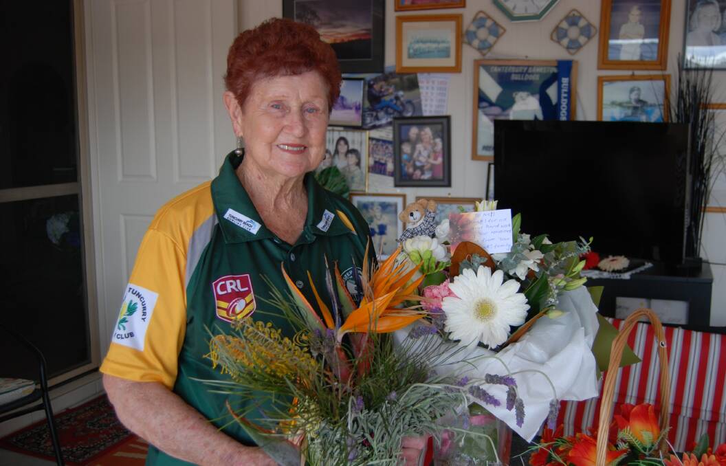 FOND MEMORIES: Nell Basham (pictured), her son Mick and grandson Dean have retired from the Forster Tuncurry Hawks Club. Nell worked as the canteen supervisor for 15 years. She is pictured with flowers given to her from the club on Saturday. 
