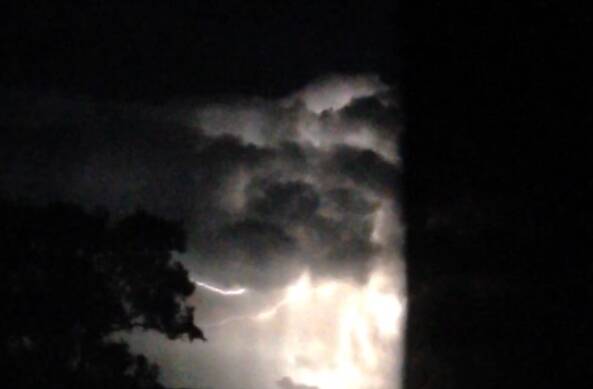 STAYING INSIDE: Jody Cooke took these photos of the storm through her fly screen door.