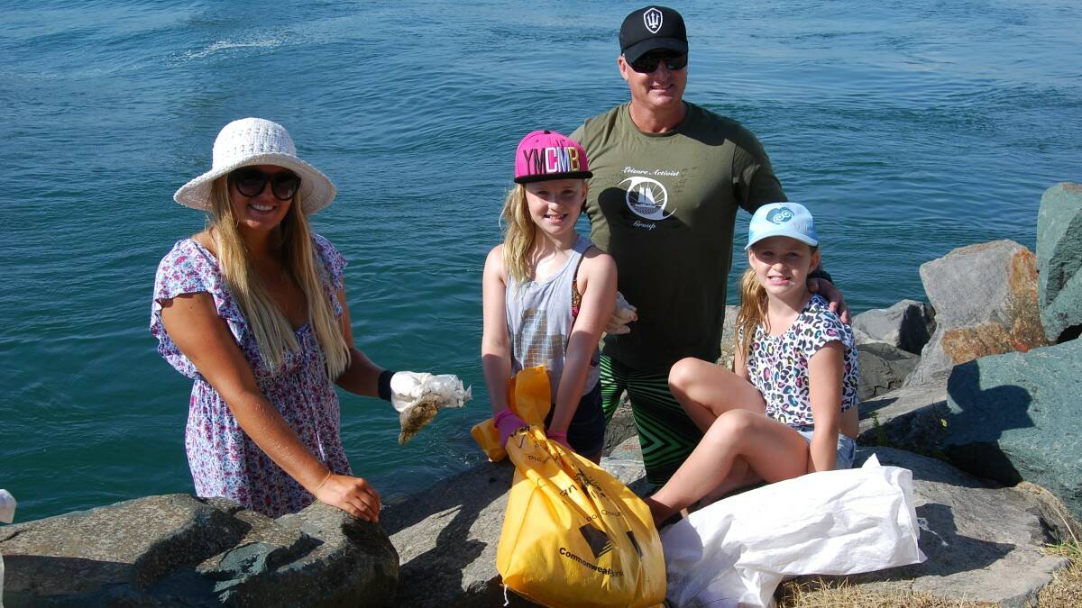 HAPPY TO HELP: Take 3 volunteer Anna Weatherstone from Byron Bay with Tuncurry locals, twins Lucy and Emily Hartman and their dad Paul.