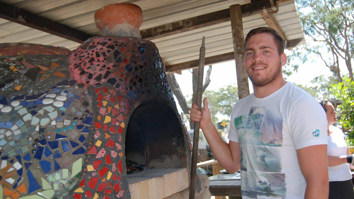 HELPING HAND: Homebase Youth Service Aboriginal youth worker Kurt Lewis helps out with the pizza oven. 