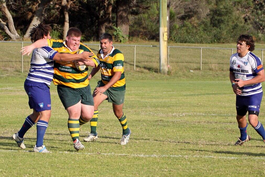 DOMINATING IN EARLY STAGES: The Forster-Tuncurry rugby union club’s powerhouse Ben Manning wards off a rival with five-eighth Jamie Fernando in support. Photo by Jason Moy.