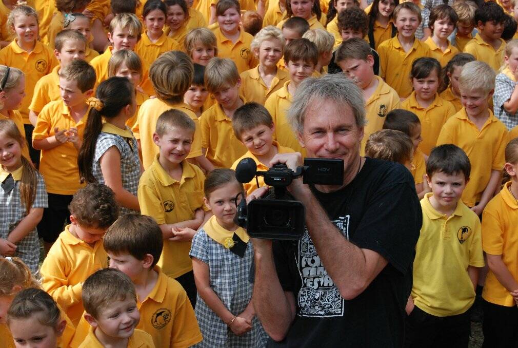 SCHOOL YARD TURNED FILM SET: Forster Film Festival Director Greg Smith with the supporting cast of ‘Catching Joy,’ a short film shot at Tuncurry Primary School last week. 