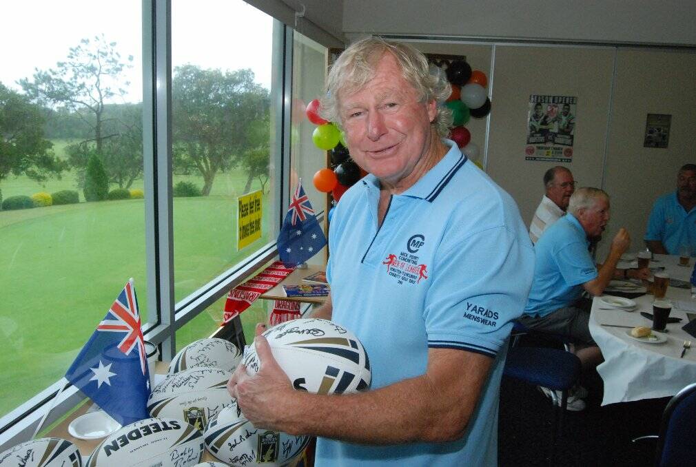 Balmain great and Forster-Tuncurry Hawks premiership winning coach Dennis Tutty signs a few auction items.
