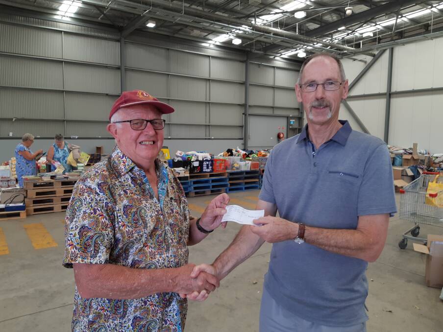 Helping farmers: Sinfonia treasurer, Peter Macfarlane presents a cheque to Taree Lions president, George Greaves, for distribution to farmers in need.