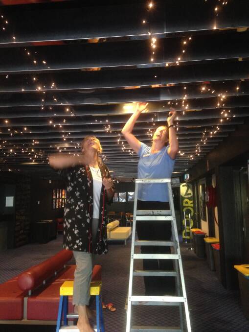 Up in lights: Ann Smith and Kim MacDonald stringing up fairy lights in the Manning Entertainment Centre foyer. 