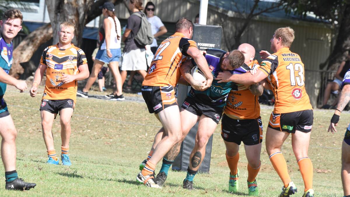Wingham Tigers defenders wrap up a Taree City ball carrier during the opening round of the preseason competition at Old Bar. The Tigers and Old Bar meet in the pre-season final on Saturday at Tuncurry. 