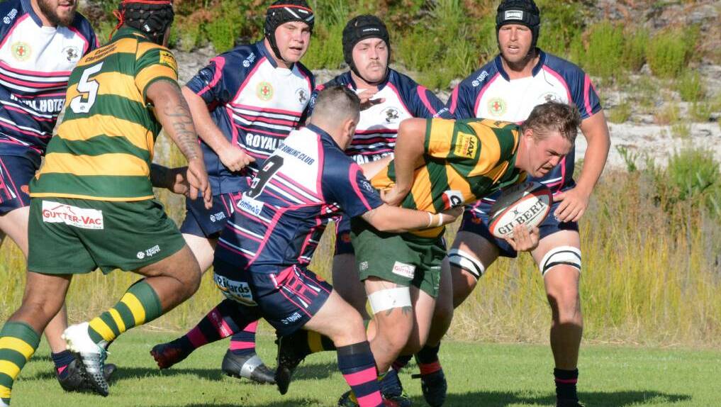 Forster Dolphins club captain Blake Polson surges through Manning Ratz defenders during a clash at Tuncurry last year.