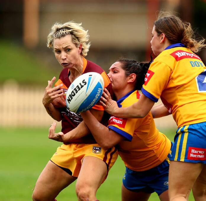 Kylie Hilder offloads when taken by defenders during the City/Country clash this year.