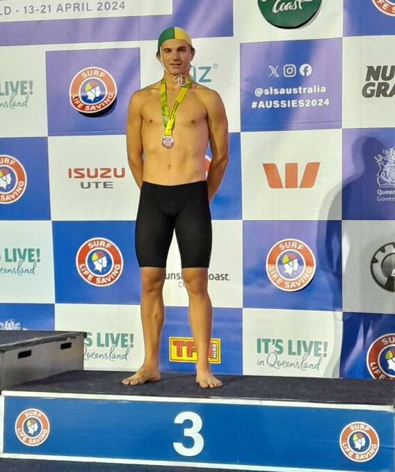 Dylan Kinkaid on the dais with his bronze medal after this third placing in the under 17 beach flags at the Australian championships.