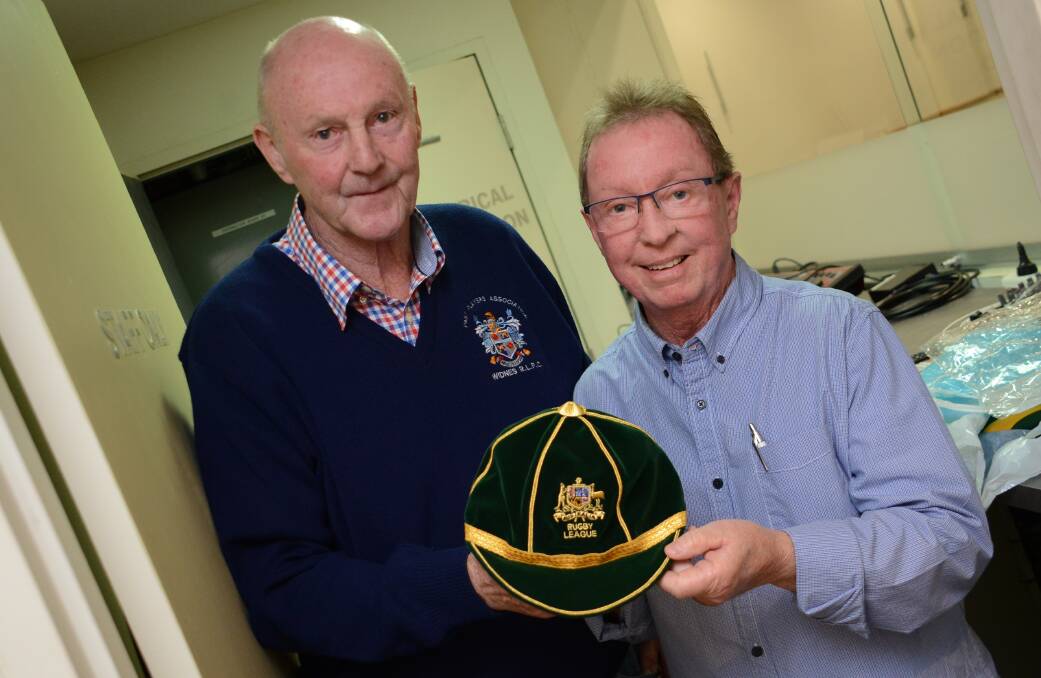 MNC branch Men of League president Brian Atherton and committee member Marshall Loadsman with the specially made Australian cap presented to Harry Wells at the function.