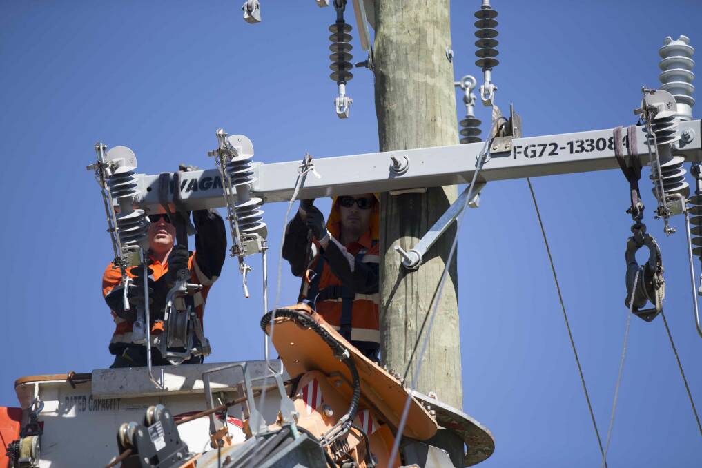 Essential Energy crew replacing a cross-arm on a power pole. Picture supplied