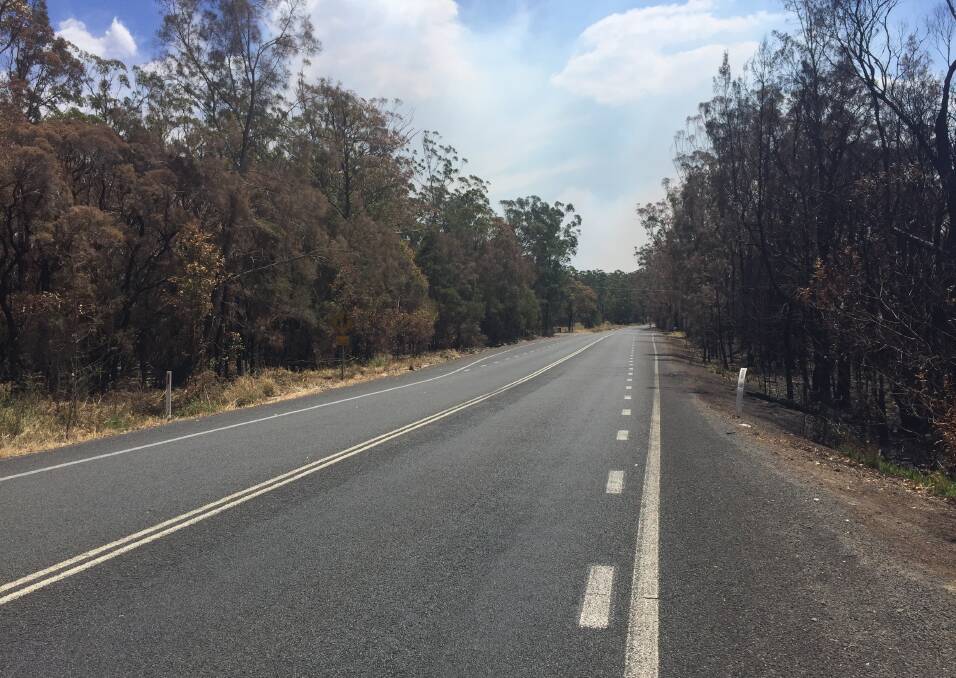 The normally busy The Lakes Way, is devoid of traffic as firefighters continue to battle blazes.