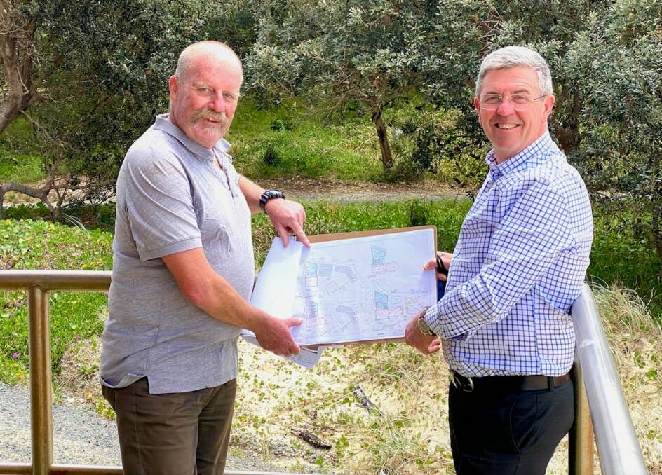Forster Surf Lifesaving Club president John Quinn and David Gillespie examine plans for Forsters Main Beach retaining wall extension.
