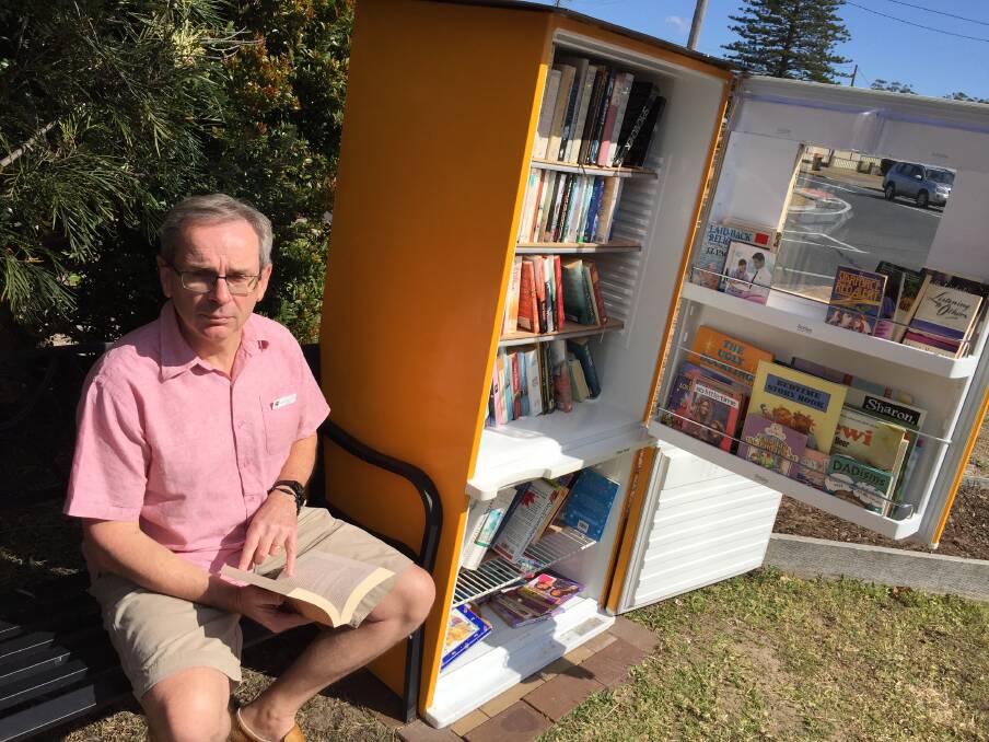 Pastor Geoff Battle browses through one of the many books available from Tuncurry's Street Library.
