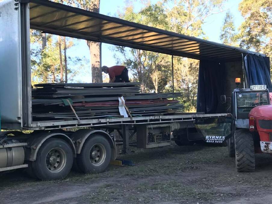 Volunteers help load up the 20 tonnes of roofing iron bound for Dunedoo.