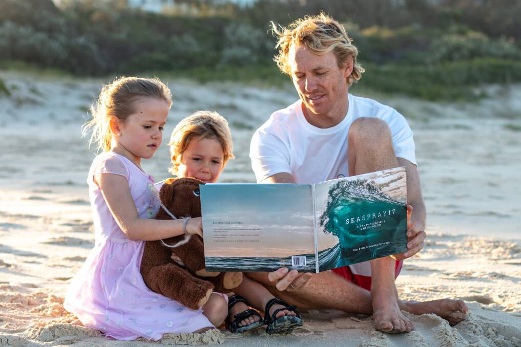  Kian and his children, Kayla and Cody, thumb through the pages of the book.