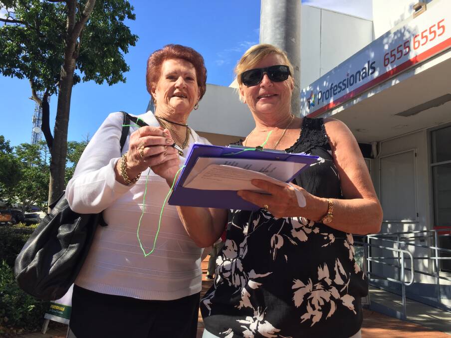 Former Great Lakes Council mayor, Jan McWilliams, who has been vocal in her opposition to the move, signs the petition. She is pictured with group volunteer, Sue Parker. 