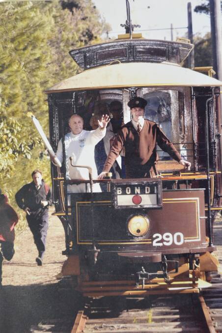 Bill Booth carrying the Olympic torch on September 11, 2000 at the Loftus Tram Museum. Photo supplied by Bill Booth
