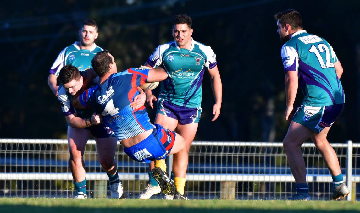 Down you go: Wauchope centre Sam Watts is tackled by the Bulls defence.