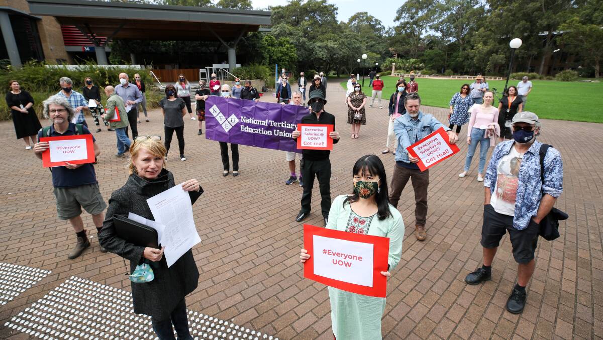 FED UP: University of Wollongong academics holding signs promoting their Every-One-UOW proposal, which they say will save jobs and calls on savings from cuts to executive salaries. Picture: Adam McLean.