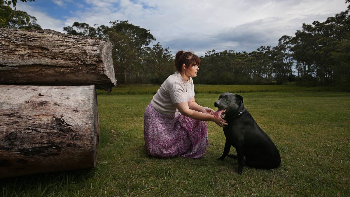 Jessica Munro with family dog, Theo. Ms Munro was forced to move out of her house after a neighbour baited Theo with fish hooks and thumb tacks. Picture by Simone De Peak 