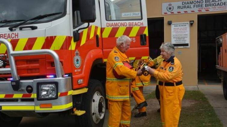 Opportunity to say thank you: When the Diamond Beach Rural Fire Brigade gets a call, founding member Jean Marcoleone is there to get the fire truck away smoothly - here handing vital field radios to Captain Russ Gray.