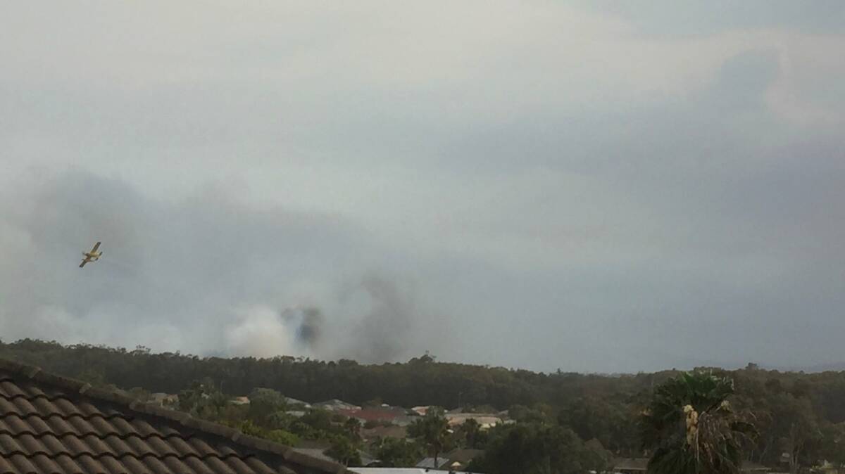 A waterbombing aircraft works to put out a bushfire burning behind Goldens Road. Photo by Leonie Dowell.