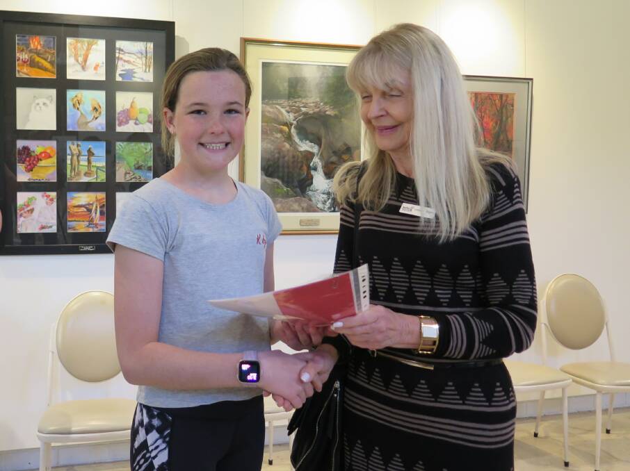 Hannah Carmichael receiving her award at the Tell Me A Story presentation.