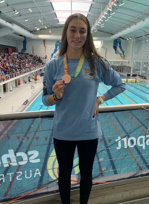 Manning Point swimmer Claire Van Kampen with the bronze medal she won in the 4 x 50m medley relay.