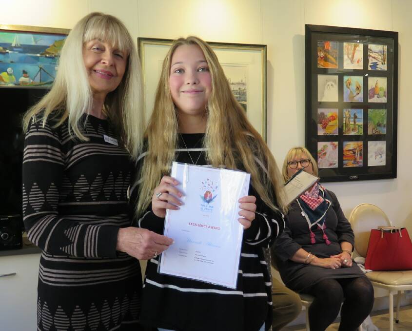 Hannah Atkinson receiving her excellence award from Tell Me A Story judge Lorraine Rogers.