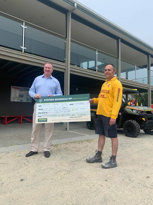 Stephen Bromhead presents a cheque for $282,750 to Pacific Palms SLSC president, Jerrad Allen.
