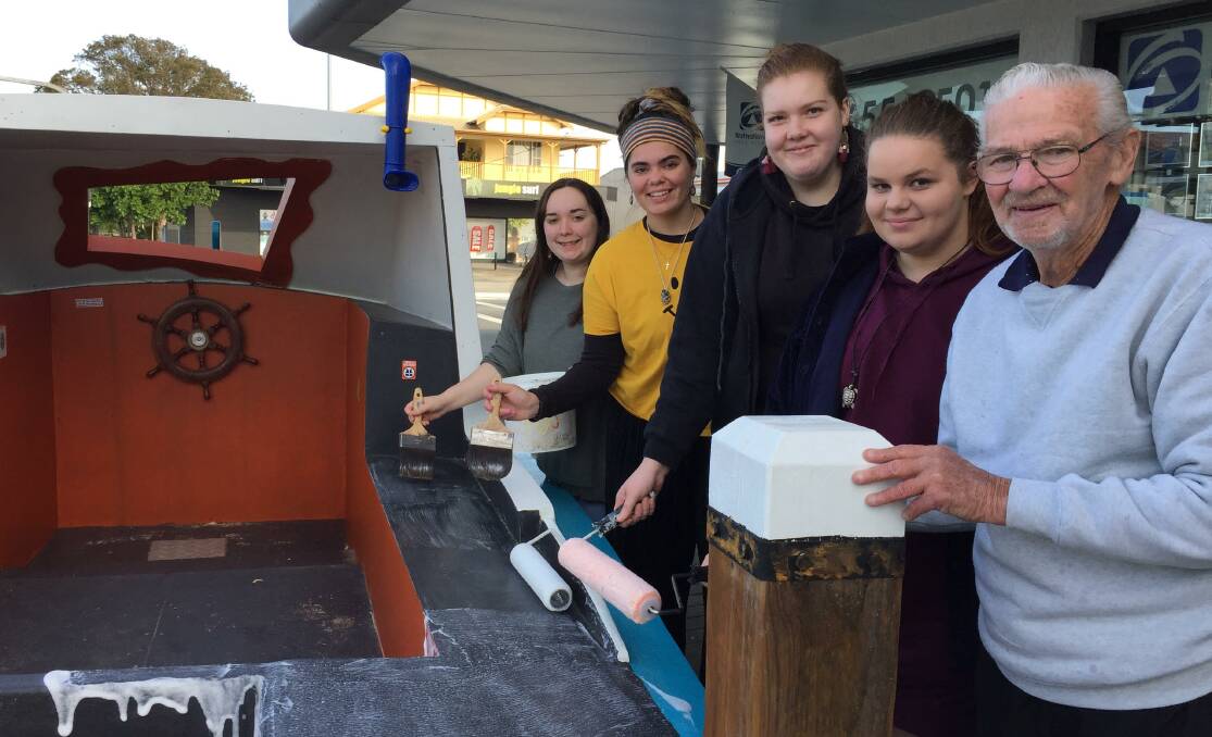 Alesco Senior College students Bryony Sudell, Kintarli Morris, Gabby Pasolini and Maddi Law help Ted make sure Tuncurry's latest additions are protected against graffiti.