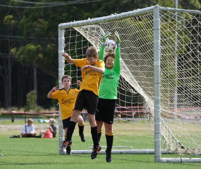 Tuncurry Forster Gold under-12 boys' goalkeeper Jonah Robertson Reynolds makes an important save.
Photo: sportsactionpix.